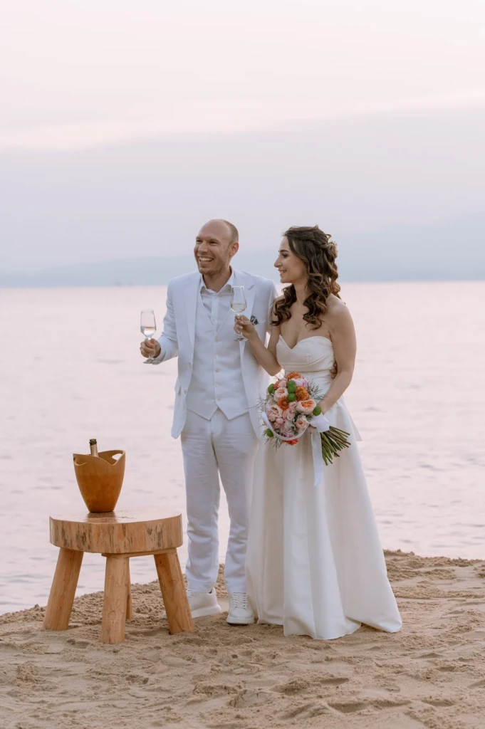 Eva and Stavros on the beach at golden hour, the bride holding a colourful bouquet