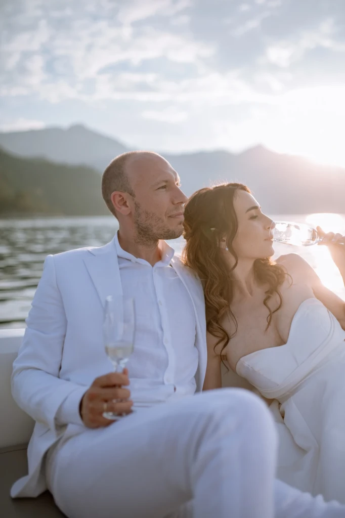 Eva and Stavros kissing on a boat at sunset with mountains across the water