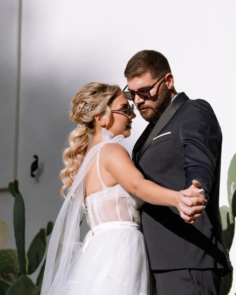 Fenia and Dimitris holding hands at sunset, wedding rings and tulle dress in detail