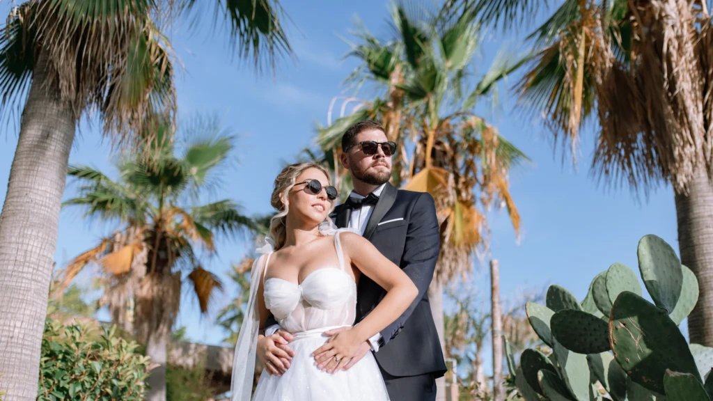 Fenia and Dimitris dancing together by a whitewashed wall on their wedding day