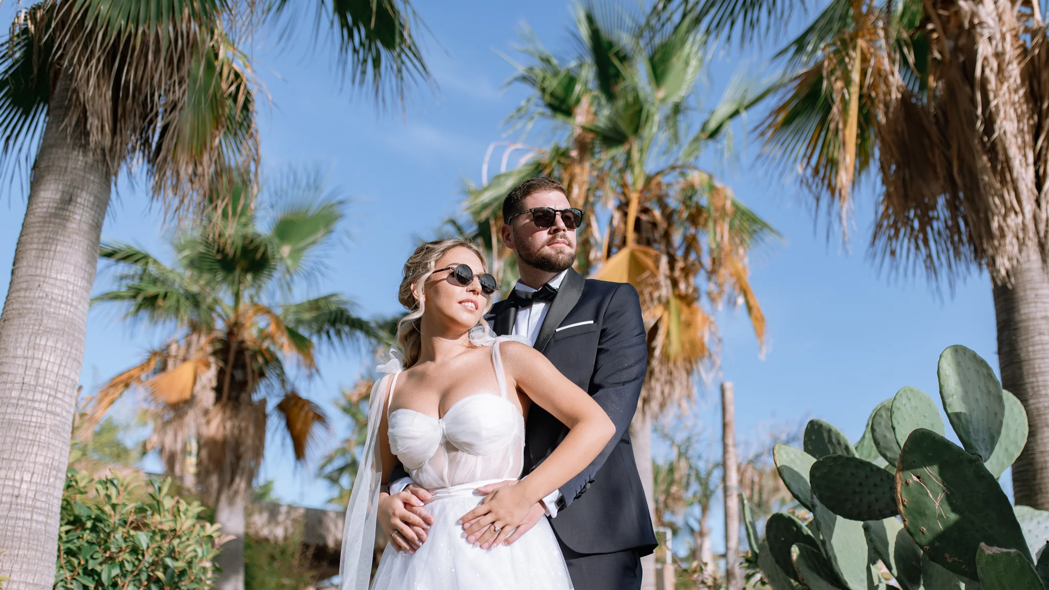 Fenia and Dimitris dancing together by a whitewashed wall on their wedding day