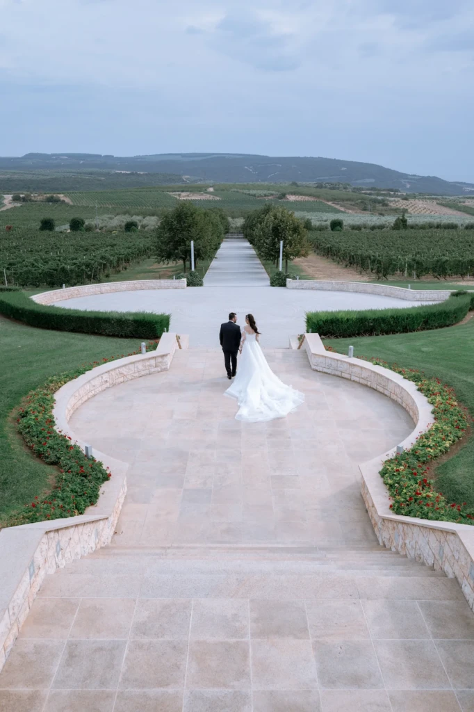 Loukiani and Giorgos walking toward the Pangaion vineyards from the gardens of Ktima Biblia Chora