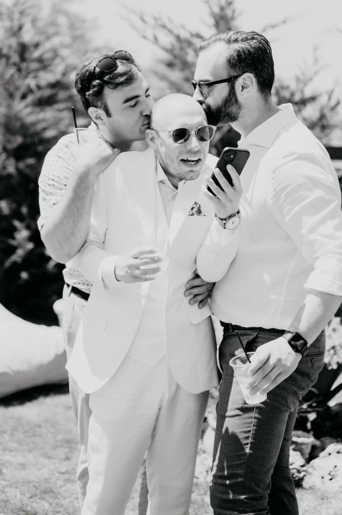 Groom Stavros lighting a cigar with a friend before the wedding, black and white
